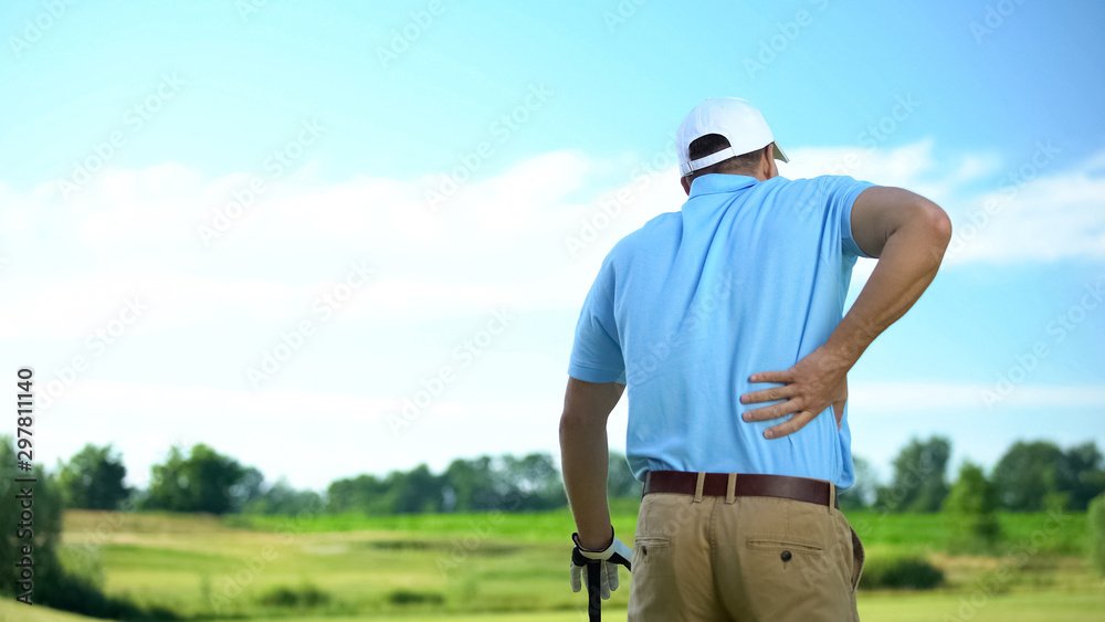 Male golf player feeling strong lower back pain after ball hitting, trauma